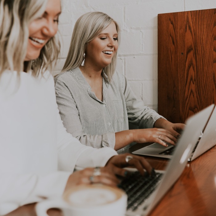 2 white women working together on computers